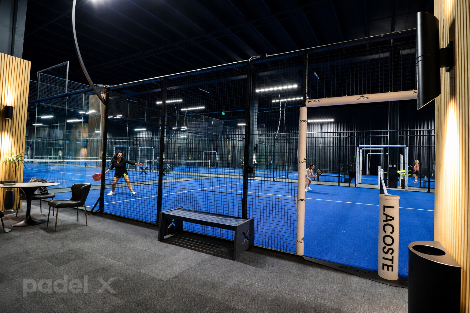 Player preparing to hit a ball on an indoor court at Padel X Boca Raton